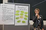 Mareike Hümmerich stellt an einer Pinnwand die Ergebnisse eines Workshops vor.